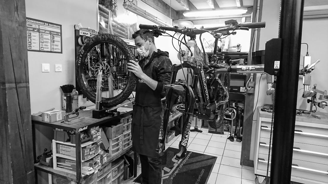 Nous pouvons voir sur la photo un technicien qui travaille sur un vélo à l'atelier